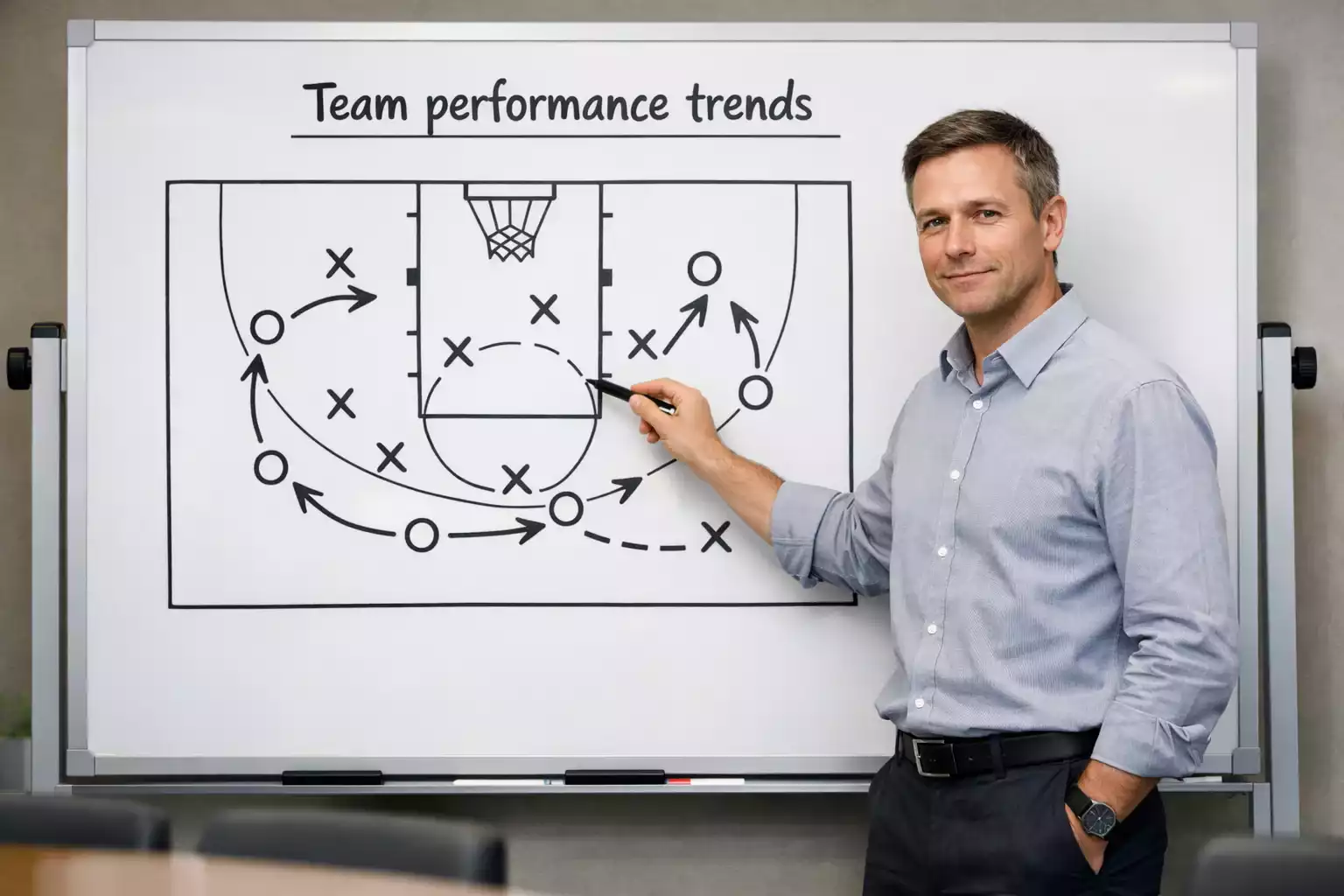 Sports analyst pointing at whiteboard showing basketball team offensive and defensive statistics comparison